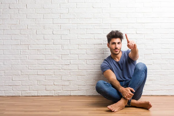 Doğal delikanlı bir numara, sayma, matematik, kendinden emin ve neşeli kavramı sembol gösterilen bir ahşap zemin üzerinde oturmak