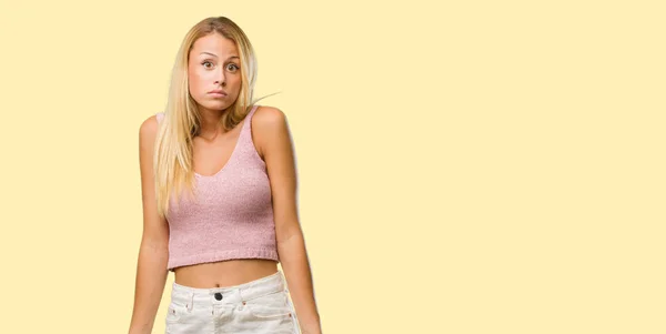 stock image Portrait of young pretty blonde woman doubting and shrugging shoulders, concept of indecision and insecurity, uncertain about something