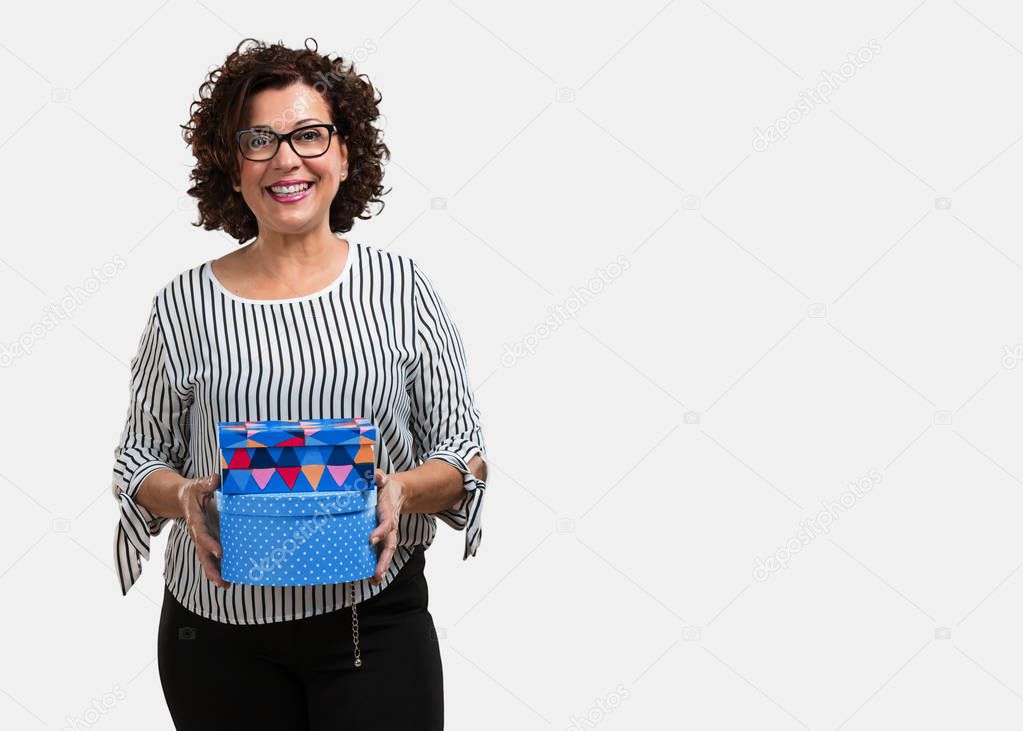 Middle aged woman cheerful and calm, holding some boxes in vintage style