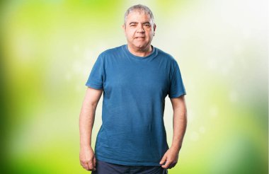 olgun erkek yeşil arka plan bulanık üzerinde gülümseyen