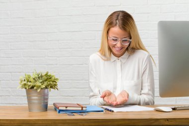 Elleriyle bir şey tutan, bir ürün, gülümseyen ve neşeli gösterilen, hayali bir nesne sunan görevleri yapmak onun masasına oturan genç öğrenci portresi