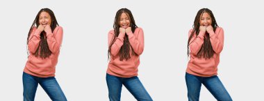 Silah gri arka plan üzerinde yükselterek fitness genç siyah kadın çok mutlu ve heyecanlı, dizi