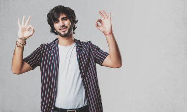 Genç yakışıklı adam neşeli ve kendine güvenen heyecanlı ve çığlık, onay ve başarı kavramı ok jest yapıyor