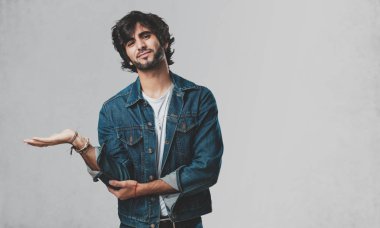 Elleriyle bir şey tutan, bir ürün, gülümseyen ve neşeli gösterilen, hayali bir nesne sunan yakışıklı delikanlı