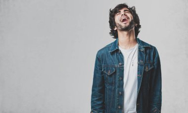 Rahat ve neşeli, gülen ve having fun, genç yakışıklı adam kendinden emin ve başarılı hissediyor