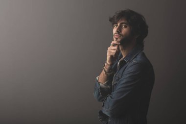 Genç yakışıklı adam neşeli ve kendine güvenen Studio kamera bakıyor 