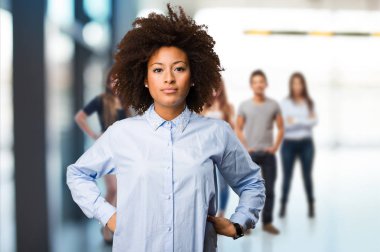 arka plan bulanık insanlarla duran genç siyah kadın