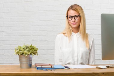 Neşeli ve büyük bir gülümseme ile kendinden emin, samimi ve içten, görevleri yapmak masasına oturan genç öğrenci portresi pozitifliği ve başarı ifade etmek