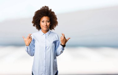 Genç siyah kadının arka plan bulanık iyi şanslar jest yapması