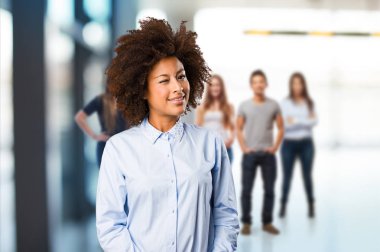 arka plan bulanık insanlarla duran genç siyah kadın