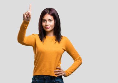 Genç güzel kadın gösteren bir numaralı simgesi sayma, matematik, kendinden emin ve neşeli kavramı