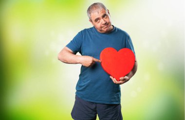 bir kalp şekli tutan olgun adam