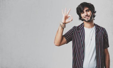 Genç yakışıklı adam neşeli ve kendine güvenen heyecanlı ve çığlık, onay ve başarı kavramı ok jest yapıyor