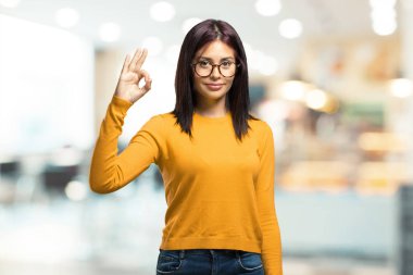 Neşeli ve heyecanlı ve çığlık, onay ve bir kafeterya başarı kavramı ok jest yapıyor kendine güvenen genç güzel kadın
