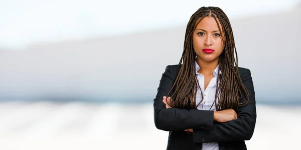 Portrait of a young black business woman very angry and upset, very tense, screaming furious, negative and crazy
