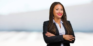 Kollarını, gülümseyen ve mutlu crossing, güvenli ve dost canlısı bir genç siyah iş kadın portresi