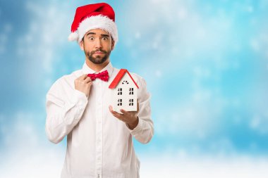 Noel gününde Noel Baba şapkası giyen genç adam