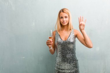 Gösterilen dört numaralı, sayma sembolü, matematik, kendinden emin ve neşeli kavramı zarif sarışın genç kadın portresi. Bir şampanya kadehi holding.