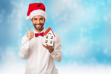 Noel gününde Noel Baba şapkası giyen genç adam