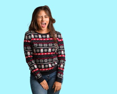 Bir Noel jersey kırpışan, komik, samimi ve kaygısız jest giyen tam vücut genç kadın