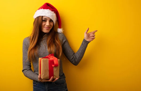 Joven Mujer Bonita Sosteniendo Regalo Señalando Lado Con Dedo — Foto de Stock