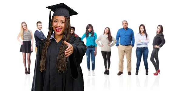 年轻毕业的黑人妇女戴辫子伸出手来问候某人或示意帮助 高兴和兴奋 — 图库照片