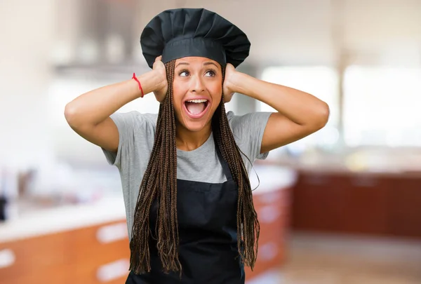 Portrait of a young black baker woman frustrated and desperate, angry and sad with hands on head