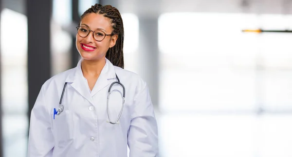 Portrait of a young black doctor woman cheerful and with a big smile, confident, friendly and sincere, expressing positivity and success