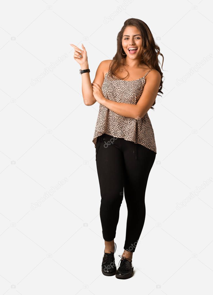 Full body young curvy plus size woman pointing to the side with finger