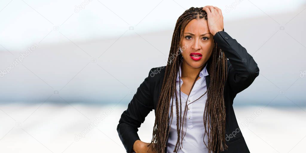 Portrait of a young black business woman worried and overwhelmed, forgetful, realize something, expression of shock at having made a mistake