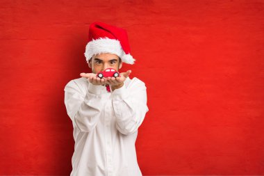 Noel gününde Noel Baba şapkası giyen genç adam
