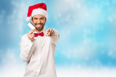 Noel gününde Noel Baba şapkası giyen genç adam