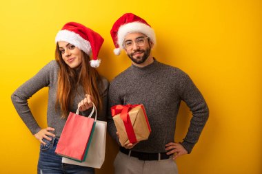 Çift veya hediyeler ve alışveriş torbaları ellerle kalça üzerinde tutan arkadaşlar