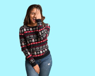 Mutlu ve covering yüz el ile bağırarak bir Noel forması giyen tam vücut genç kadın