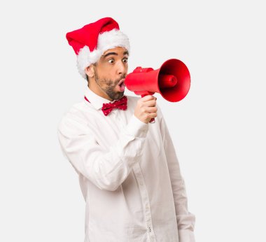 Noel gününde Noel Baba şapkası giyen genç adam