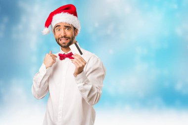 Noel gününde Noel Baba şapkası giyen genç adam