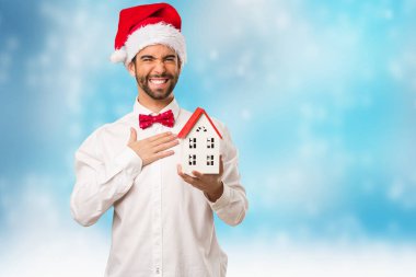 Noel gününde Noel Baba şapkası giyen genç adam