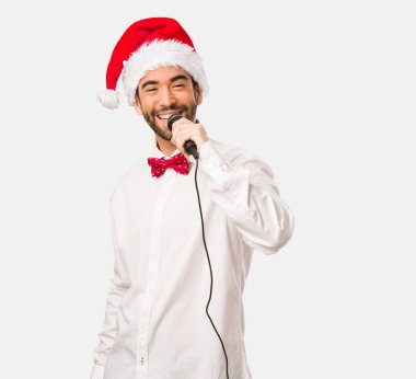 Noel gününde Noel Baba şapkası giyen genç adam