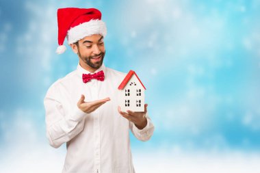 Noel gününde Noel Baba şapkası giyen genç adam