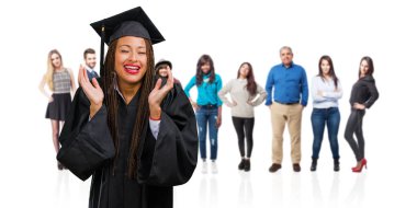 Genç siyah kadın gülüyor örgü giyen mezun oldu ve eğleniyor, rahat ve neşeli, kendinden emin ve başarılı hisseder