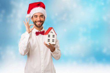 Noel gününde Noel Baba şapkası giyen genç adam