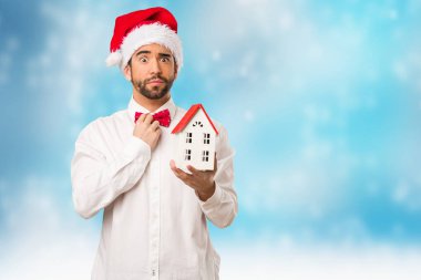 Noel gününde Noel Baba şapkası giyen genç adam