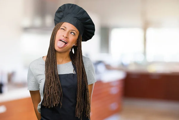 Portrait of a young black baker woman expression of confidence and emotion, fun and friendly, showing tongue as a sign of play or fun