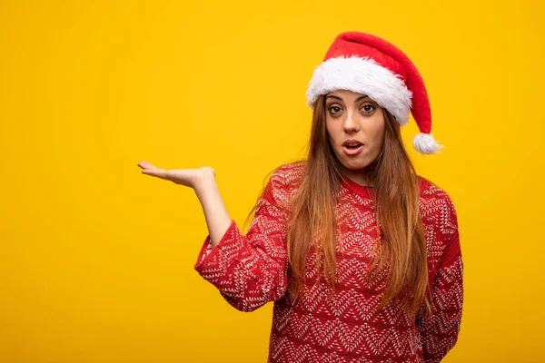 Junge Frau Mit Weihnachtsmütze Die Etwas Auf Der Hand Hält — Stockfoto