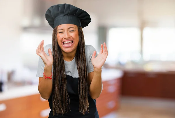 Portrait of a young black baker woman laughing and having fun, being relaxed and cheerful, feels confident and successful