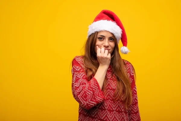 年轻女子戴着圣诞老人的帽子咬指甲 紧张和非常焦虑 — 图库照片