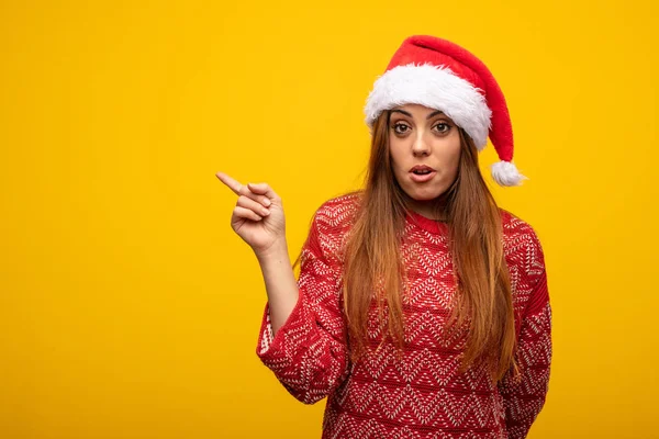 Jovem Mulher Usando Chapéu Papai Noel Apontando Para Lado — Fotografia de Stock