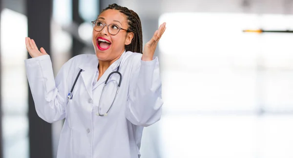 Portrait of a young black doctor woman laughing and having fun, being relaxed and cheerful, feels confident and successful