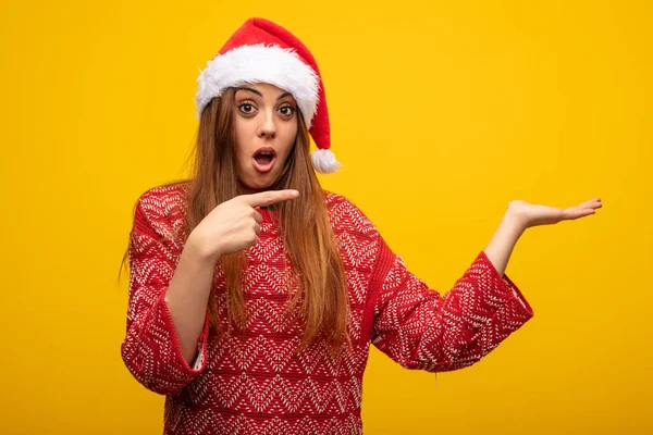Ung Kvinna Som Bär Santa Hatt Hålla Något Med Handen — Stockfoto