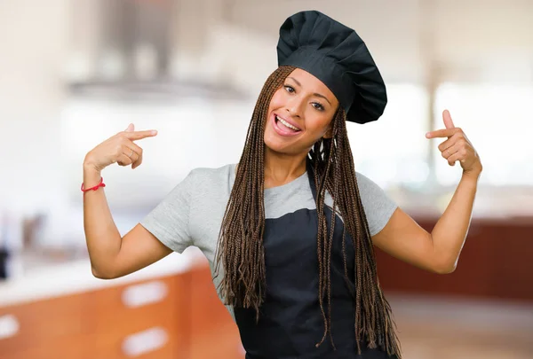 Portrait of a young black baker woman proud and confident, pointing fingers, example to follow, concept of satisfaction, arrogance and health